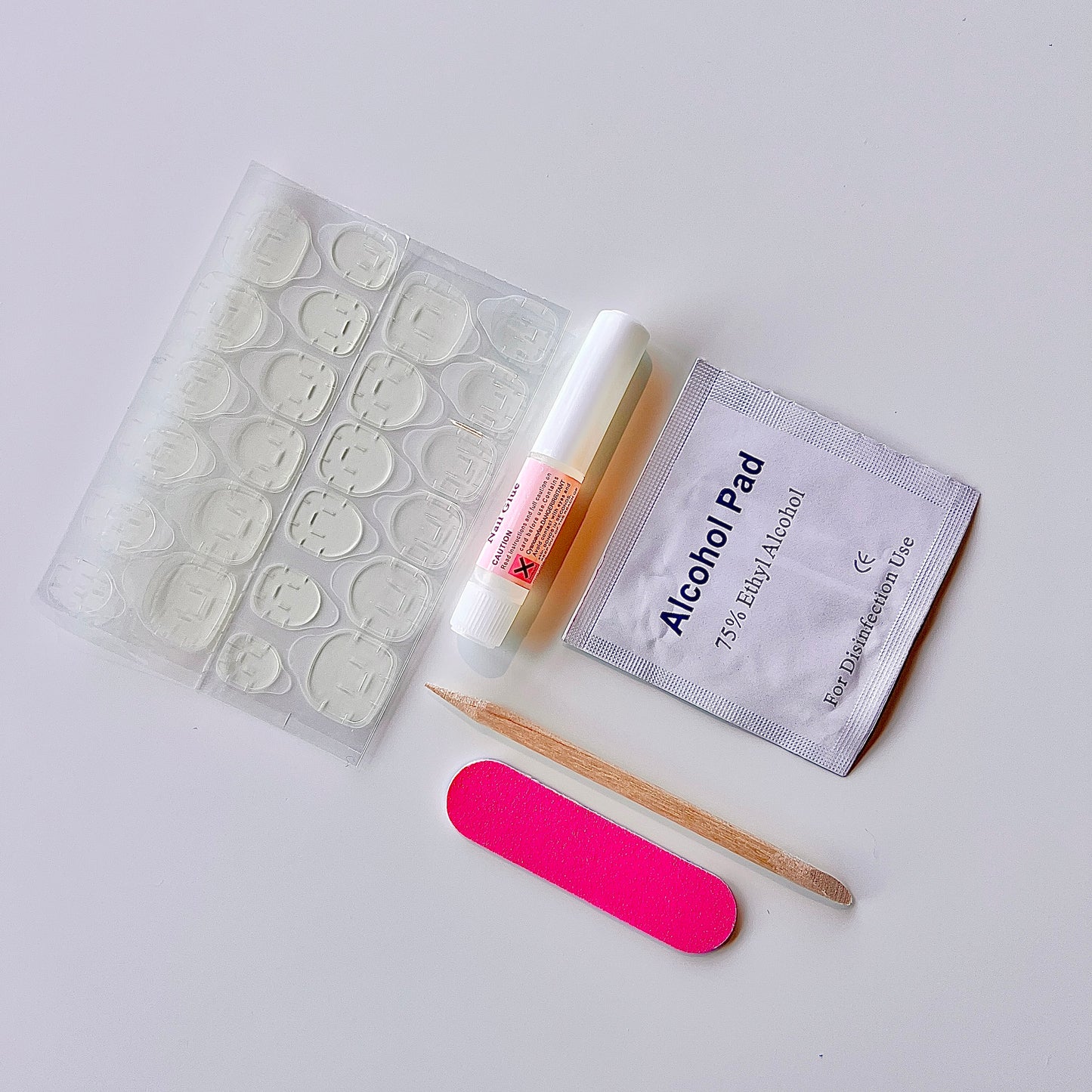 Nail care kit with alcohol pad, brush, and file on white background